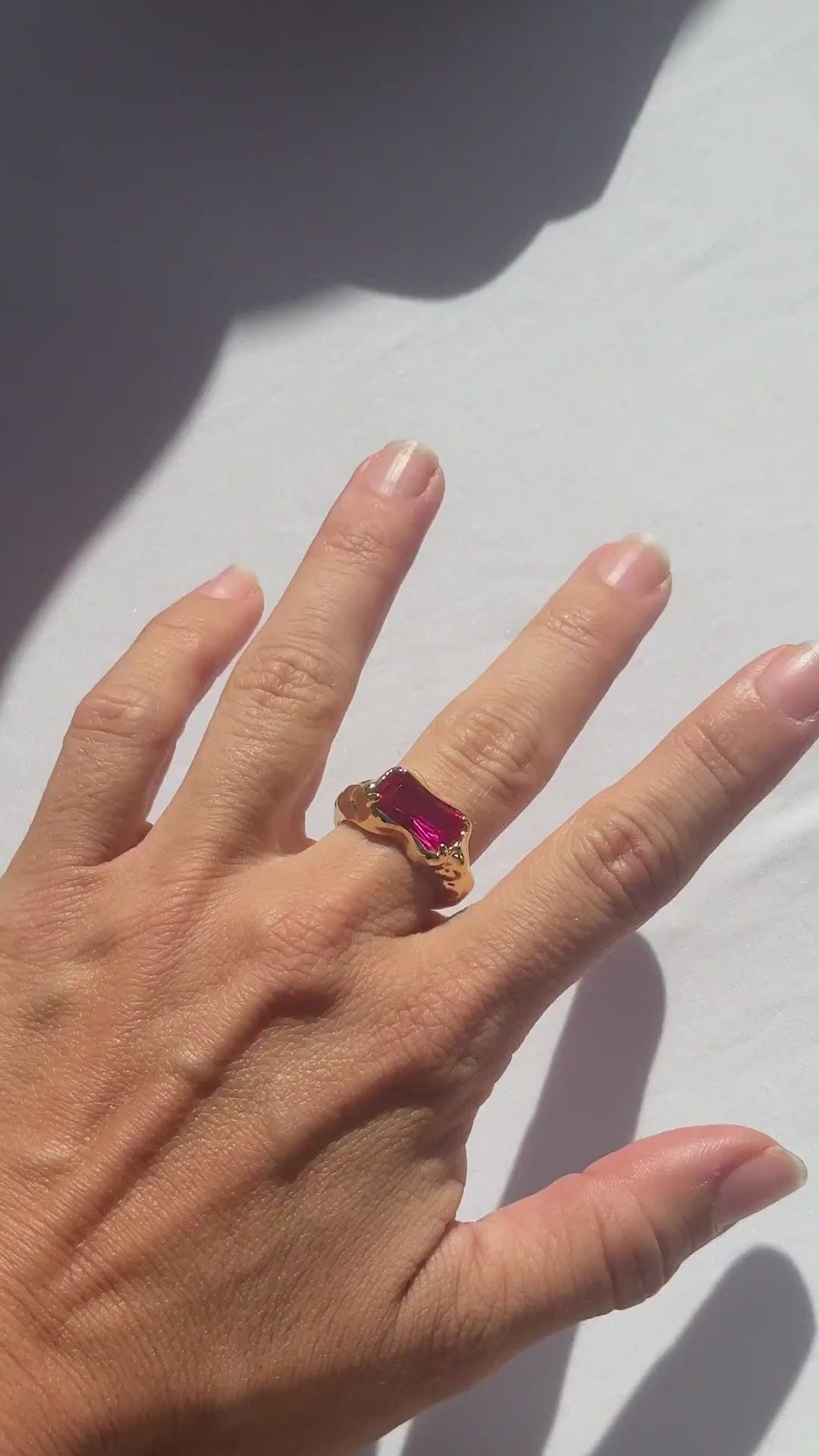 Wave Bar Ring in pink tourmaline worn on the hand in sunlight