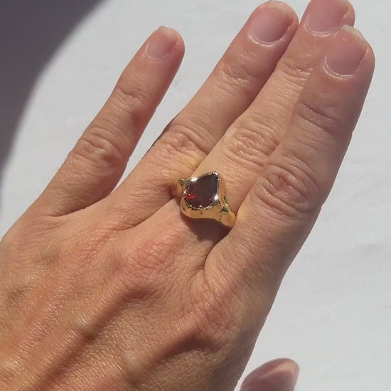 Garnet Tear Ring in rhodolite garnet worn on the hand in sunlight